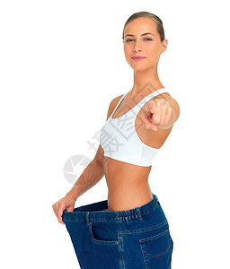 健康 减肥和女人用牛仔裤指着手 腰部很瘦 在白色背景下被隔离 微笑 医疗保健和健康 抽脂 节食和大裤衩的快乐女孩背景图片