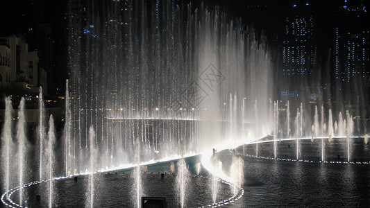 晚上在迪拜的舞蹈喷泉投影机旅行奢华照明吸引力地标展示数字假期办公室背景图片