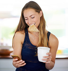 女人用她的手机 吃吐司和喝咖啡 她的幸福感取决于一个舒适的早餐背景图片