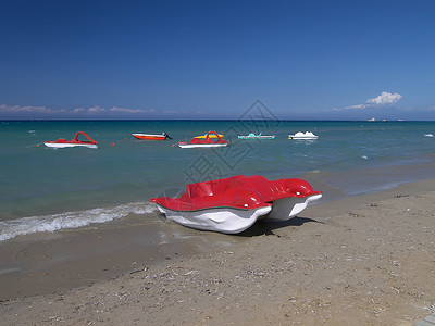 海滩上的红船轮背景图片