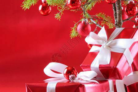 圣诞树下最有品味的红色礼物 有深厚的红色背景 红色的 假期背景图片