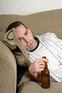 醉汉人 独自的 说谎 沙发 长椅 轻松 啤酒 瓶子 喝懒惰的高清图片素材