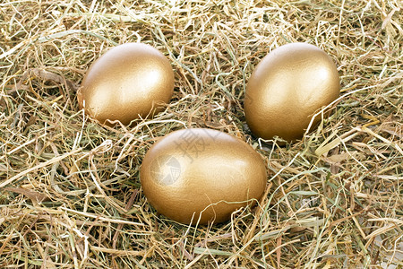 三个金蛋圆台三个金蛋在稻草中背景