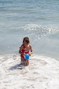 小女孩在海滩上跟一个酒桶玩耍 自然 白色的 水户外高清图片素材