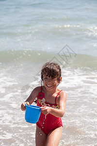 小女孩在海滩上跟一个酒桶玩耍 孩子 波浪 户外水高清图片素材