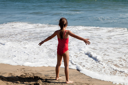 小女孩在等待海浪的来临红色的高清图片素材