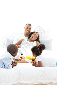 幸福的家庭在卧室吃早饭愉快的高清图片素材