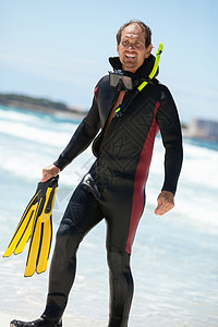 在海滩上戴潜水衣的男性潜水员 身穿潜水服在潜水面罩 鳍 夏天图片