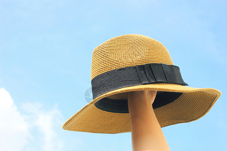 女人手握着蓝天的巴拿马帽子 问候语 抓住 毡帽 时尚的图片