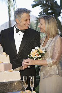 快乐的一对夫妇 切结婚纪念蛋糕在一起背景图片