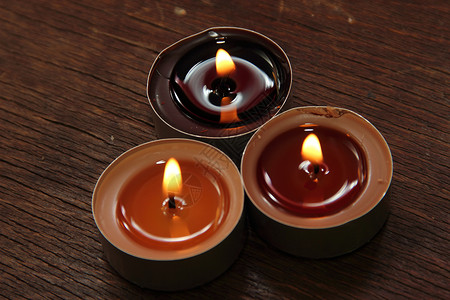 三根棕色调的蜡烛 苹果 新年 圣礼 假期 芳香 棕色的背景图片