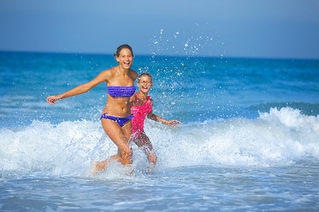 女孩在海滩上跑 自然 快乐的 蓝色的 天空 乐趣 阳光 童年美丽高清图片素材