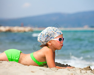 女孩在海滩上 阳光 棕褐色 说谎 假期 日光浴 游泳衣图片
