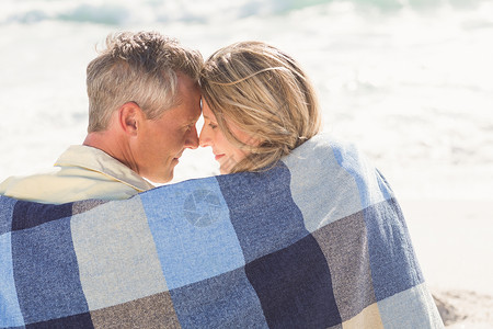幸福的一对情侣用毯子包起来 假期 晴天 海 漂亮的背景图片