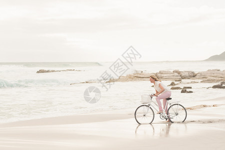 骑自行车时的伤身妇女 放松 自由的 晴天 漂亮的 休闲服装背景图片