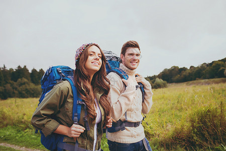 带背背包徒步的一对微笑的夫妇 活动 时间 树木假期高清图片素材