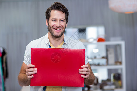 微笑的男人拿着红色的空白标志牌背景图片