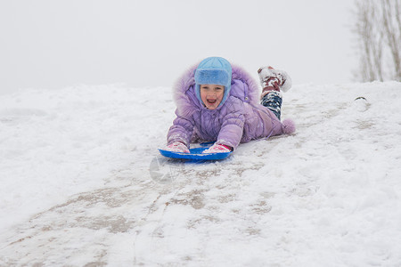 女孩在他肚子上滚下来 头部一雪滑雪高清图片