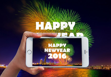 手持智能手机在2016年快乐新年拍照 节日背景图片