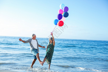持有气球的老年夫妇 女性 水 双手 假期 快乐 代背景图片