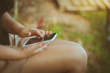 在公园使用智能手机的年轻妇女 社会的 互联网 早晨图片