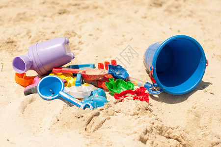 沙沙中的玩具 乐趣 夏天 塑料 铲 桶 蓝色的背景图片