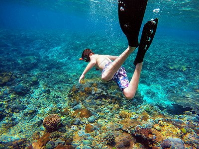 巴厘岛潜水水下拍摄一个年轻男孩的潜泳背景