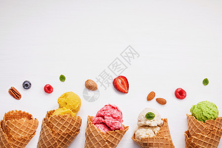 多彩的冰淇淋 带锥子 和各种水果草莓 蓝色 球 营养背景图片