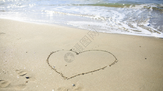 在沙滩上画着爱心的标志 海 季节 浪漫的 浪漫 信背景图片