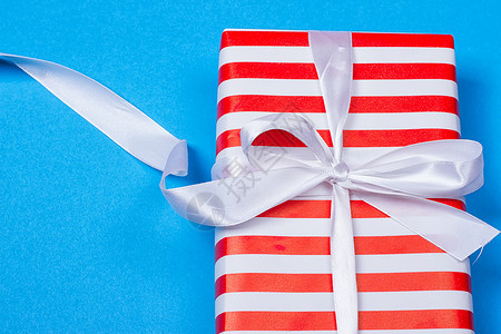 以红色和白色包装带丝带的礼品 桌子 蓝色的 季节背景图片