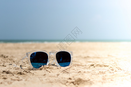沙滩上有透明覆盖的太阳镜眼镜 夏天 天空背景图片