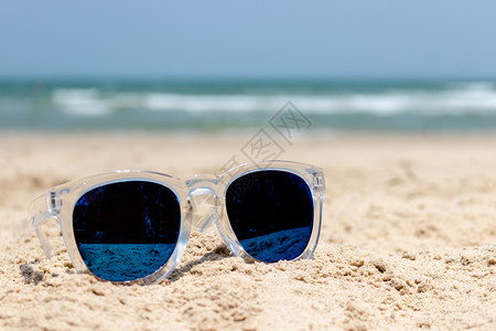 沙滩上有透明覆盖的太阳镜眼镜 海 天空 热带背景图片