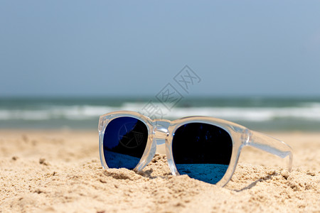 沙滩上有透明覆盖的太阳镜眼镜 美丽的 热带 假期背景图片