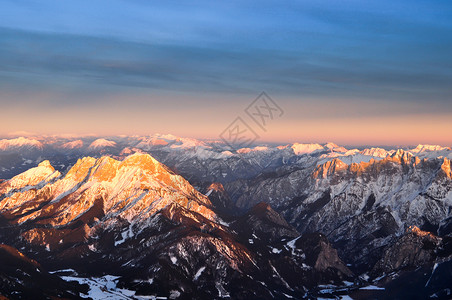日落时阿尔卑斯山峰在奥地利上空的空中观察地标高清图片素材