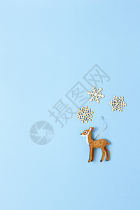 圣诞装饰 自然主义玩具狍子和淡蓝色背景上的三片小木雪花 复制空间 节日 新年的概念 垂直 平躺 最小的风格 顶视图背景图片