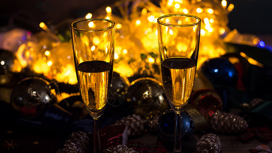 圣诞餐桌上的香槟玻璃杯 和圣诞玩具一起 快乐的派对高清图片素材
