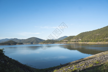 阳光明媚的一天 美丽的湖泊环绕在山上 攀登晴天高清图片素材
