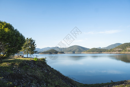 阳光明媚的一天 美丽的湖泊环绕在山上 顶峰春天高清图片素材