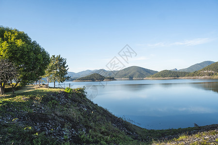 阳光明媚的一天 美丽的湖泊环绕在山上 旅行日出高清图片素材