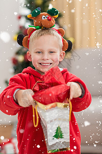 小男孩带着头巾喜悦的小男孩在镜头前笑着带礼物的喜悦小男孩的综合形象背景
