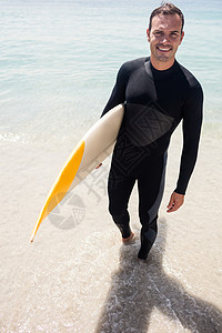 在海滩上拿着冲浪板的快乐冲浪者 潜水服 爱好 假期图片