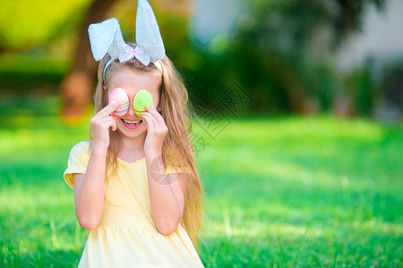 穿洋装兔子春日穿兔子耳朵和复活节鸡蛋的可爱小姑娘 可爱的背景