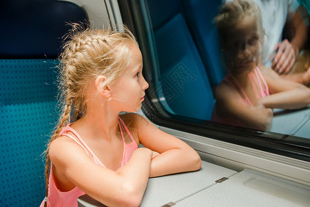 可爱的小孩在车窗外看着车窗 在车开动的时候背景图片