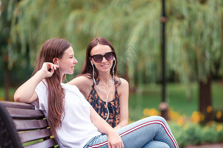 坐在夏天公园的长椅上的好朋友们 休息 自然 幸福背景图片