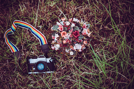 带有花束的古老照相机 在草原上背景图片