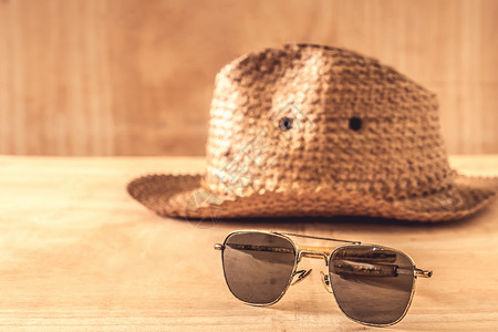 木制桌上的太阳镜和帽子 夏天 假期 时尚 眼镜 配饰背景图片