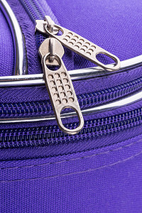 紫罗兰色手提箱上拉链的拉环和链条 闪亮的 拉拔器背景图片
