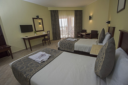 双床在一个酒店房间的豪华套房里 双人床 窗帘 电视图片