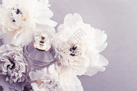 紫花香水瓶作为奢华香水产品 其背景是小马花 豆香广告和美容品牌 花朵 柑橘背景图片
