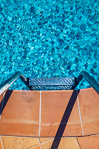 用楼梯游泳泳池 在蓝色游泳中抓条梯子 绿松石背景图片